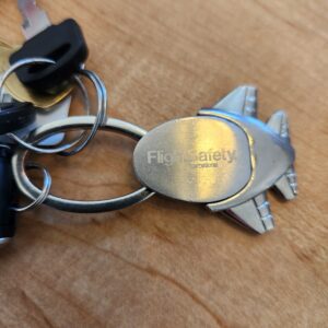 Close-up of keys and a keychain on a wooden surface.
