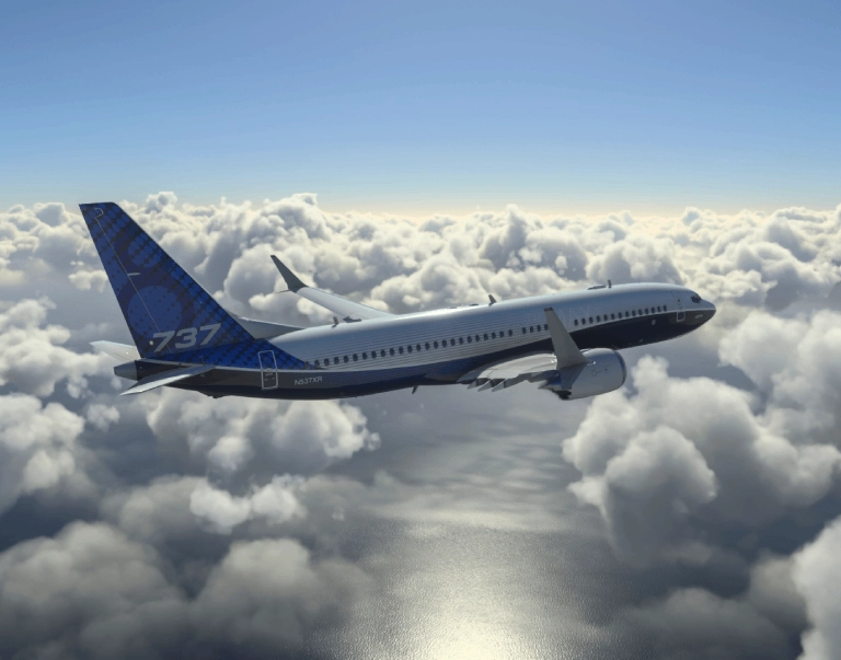 A Boeing 737 airplane flying above the clouds on a sunny day.